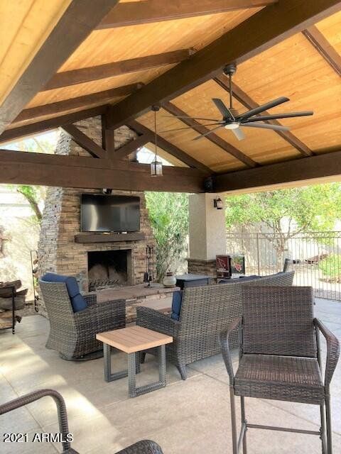 A patio with a ceiling fan and a fireplace