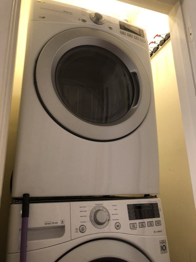 A washer and dryer are stacked on top of each other in a laundry room.