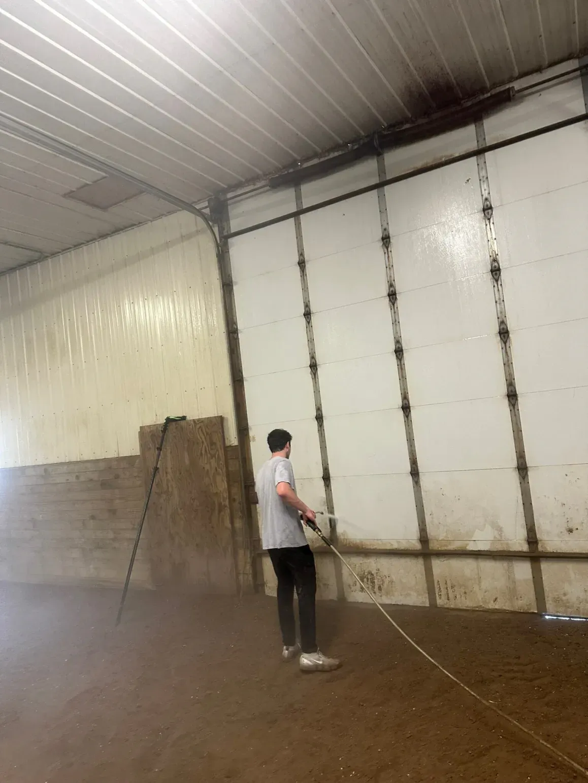 A person sprays water on a wall inside a building.
