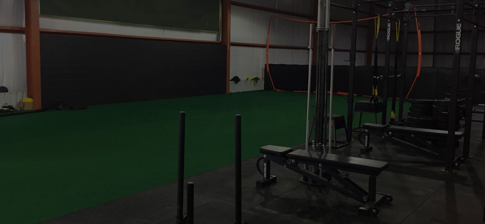 An indoor gym with workout equipment and space to train.