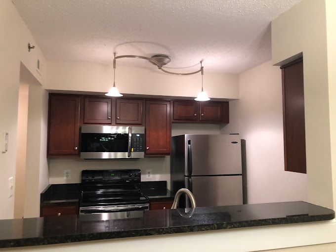 Kitchen with dark cabinets, stainless steel appliances, and a granite countertop.