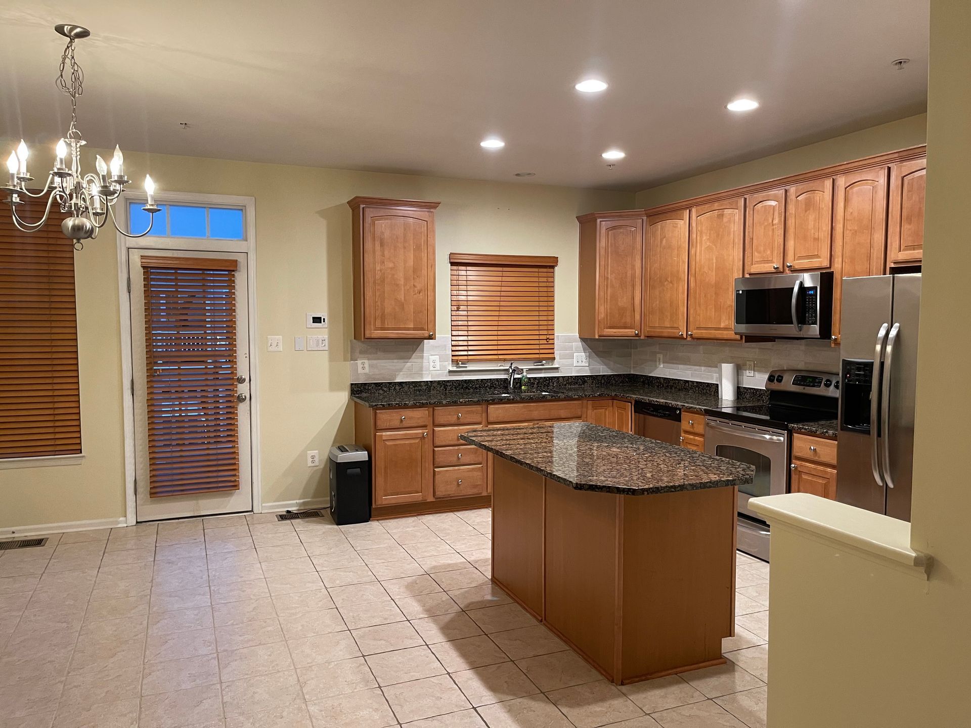 Kitchen with wooden cabinets, granite countertops, and stainless steel appliances.