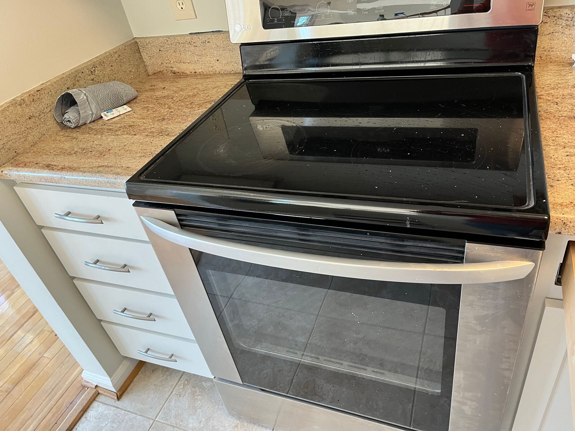 Stainless steel electric range with a black cooktop in a kitchen.