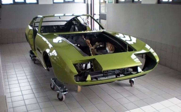Carrozzeria verde lime su un carrello in un garage, in fase di restauro.