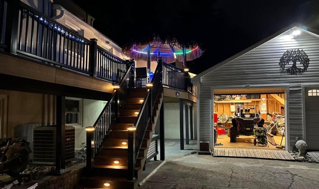 A house with a deck and stairs leading up to it at night.