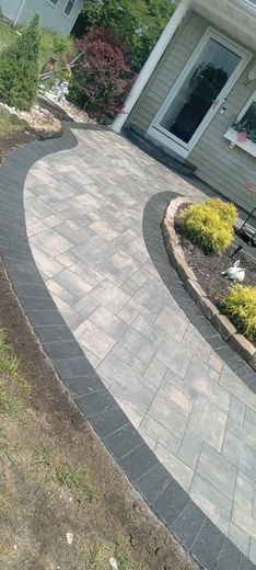 A brick walkway leading to the front door of a house.