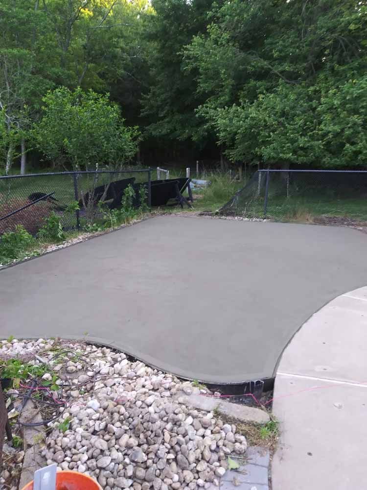 A concrete driveway is being built in a backyard.