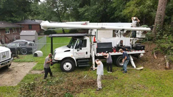 A group of men are working on a truck in a yard.