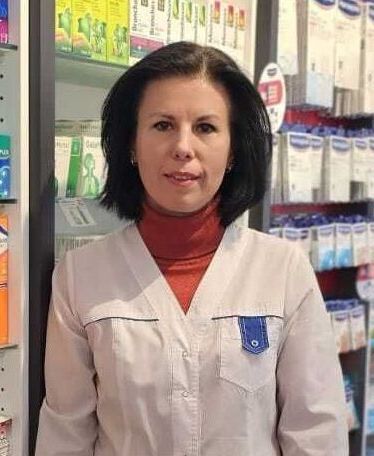 Eine Frau steht vor einem Regal in einer Apotheke.