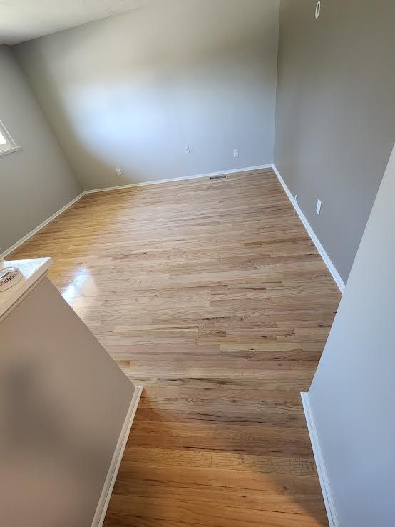 Hardwood floors and gray walls in a room, viewed from above.