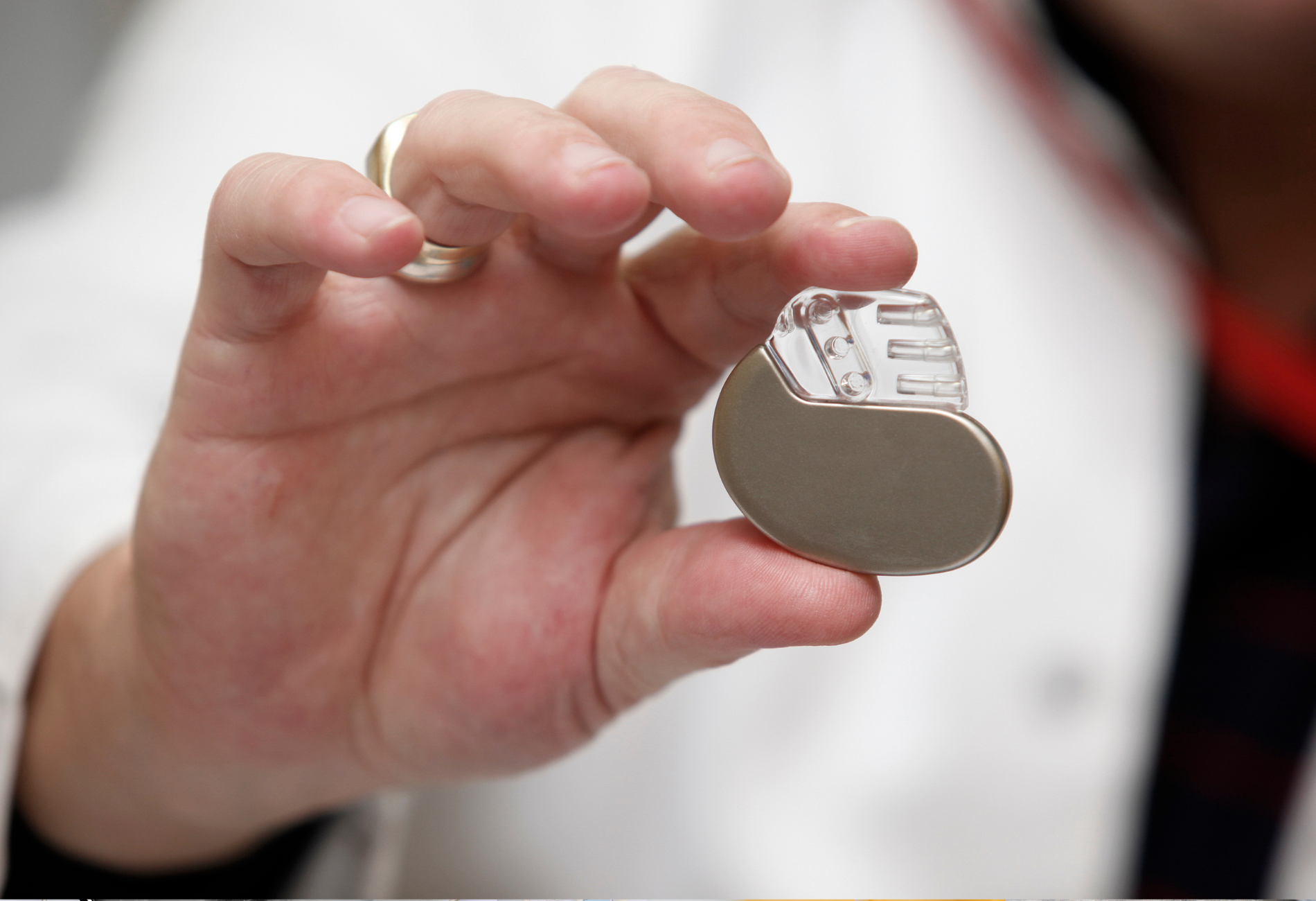 a person in a lab coat is holding a small device in their hand