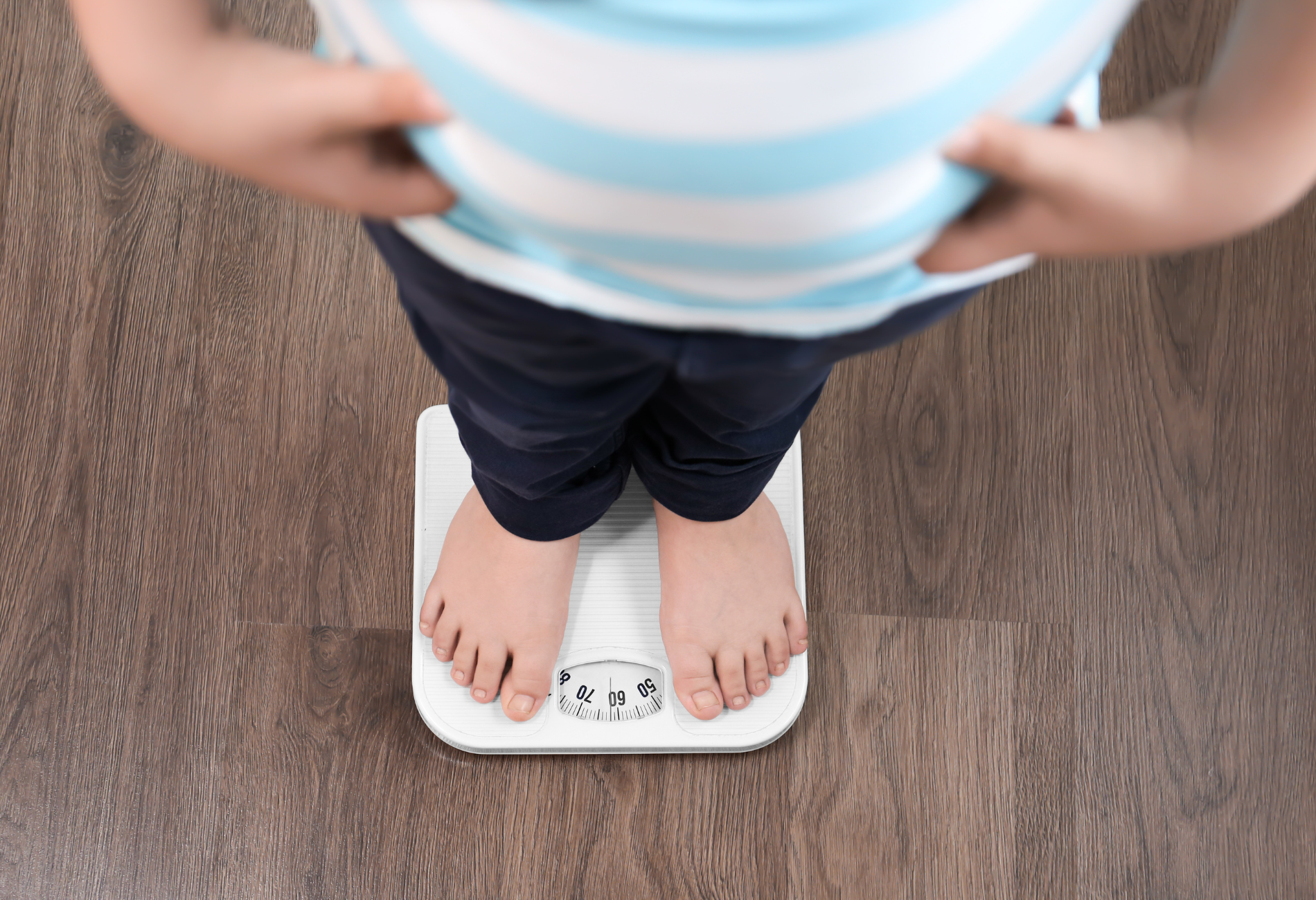 a person is standing on a scale with their hands on their hips .