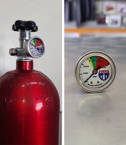 Red gas cylinder with a gauge showing pressure; the needle indicates it is in the red zone.