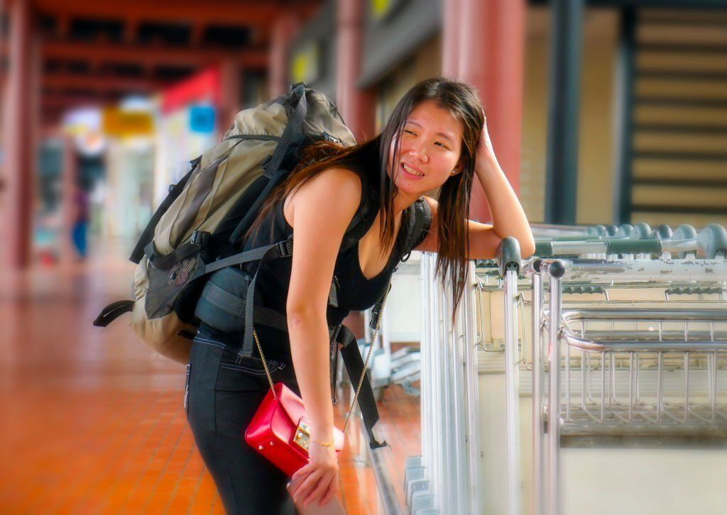 Frustrated Asian woman is leaning on a row of trolley.