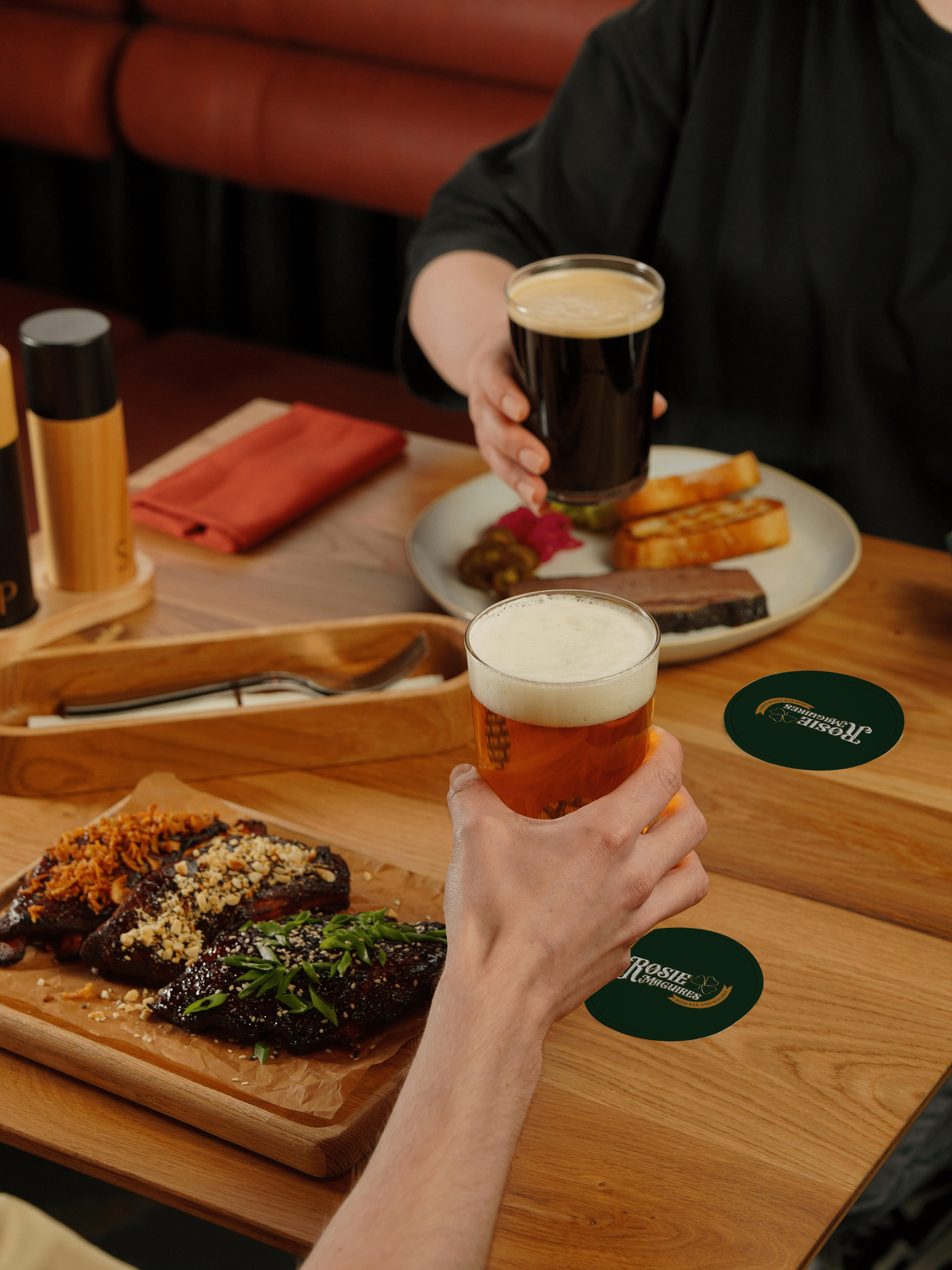 people at table with food and pints of beer