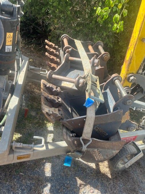 A Bucket on a Trailer Attached to a Yellow Excavator — Mini Digger and Trailer Hire in Mareeba, QLD