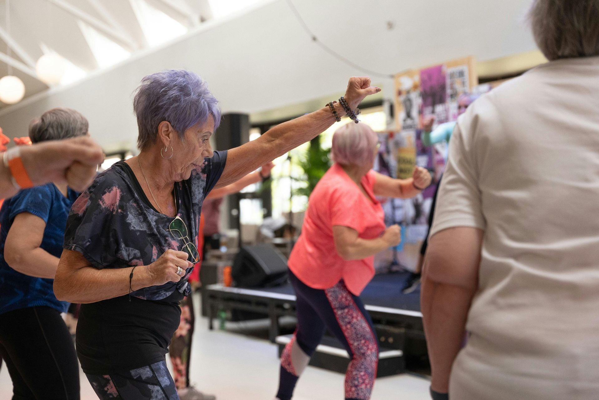 A group of older women are dancing together in a room.