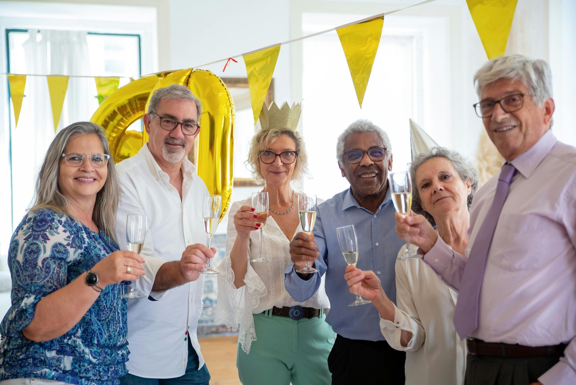 A group of people are toasting with champagne at a birthday party.