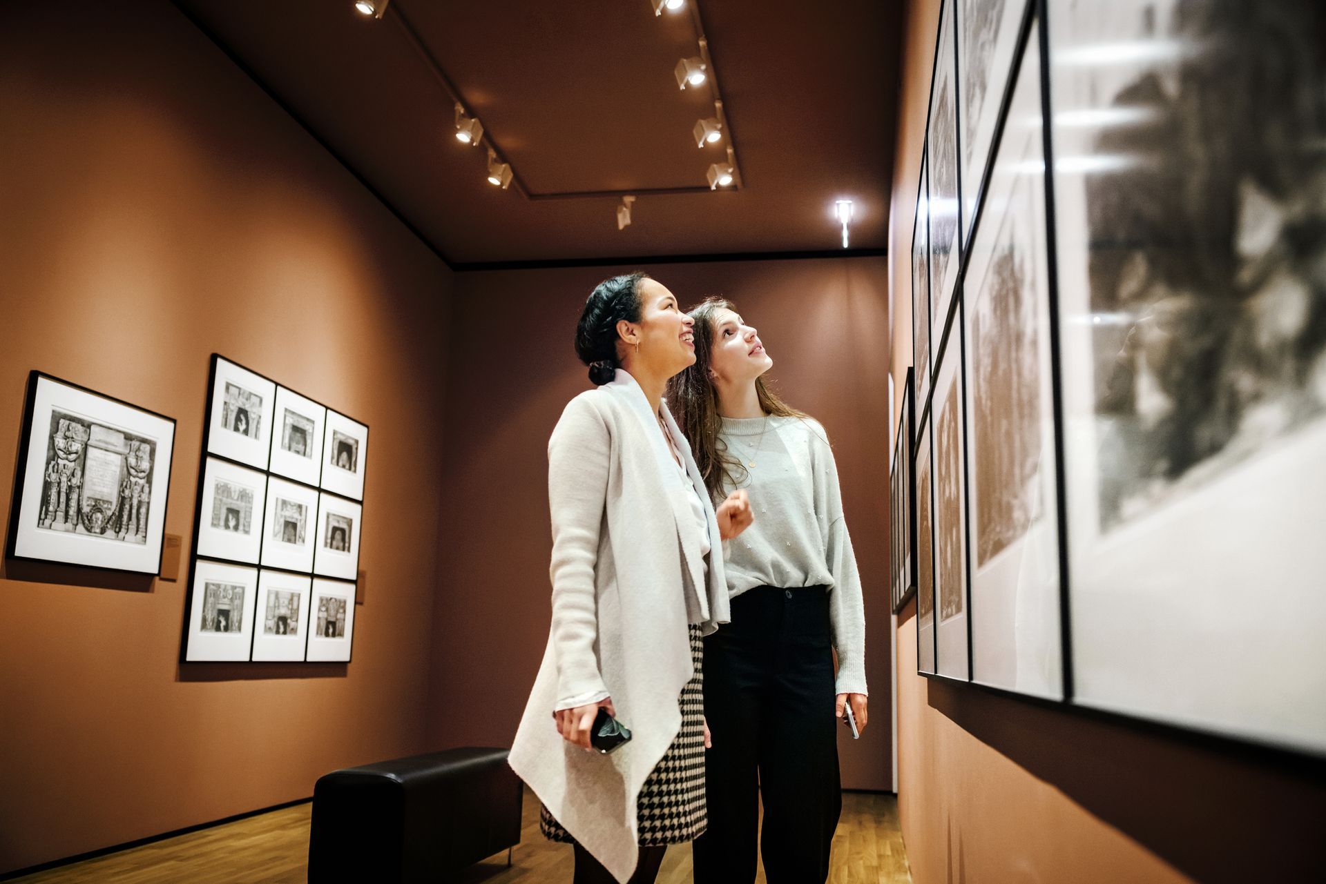 Two women stand closely together in a museum, showcasing museum lighting products. Two women stand closely together in a museum, showcasing museum lighting products.