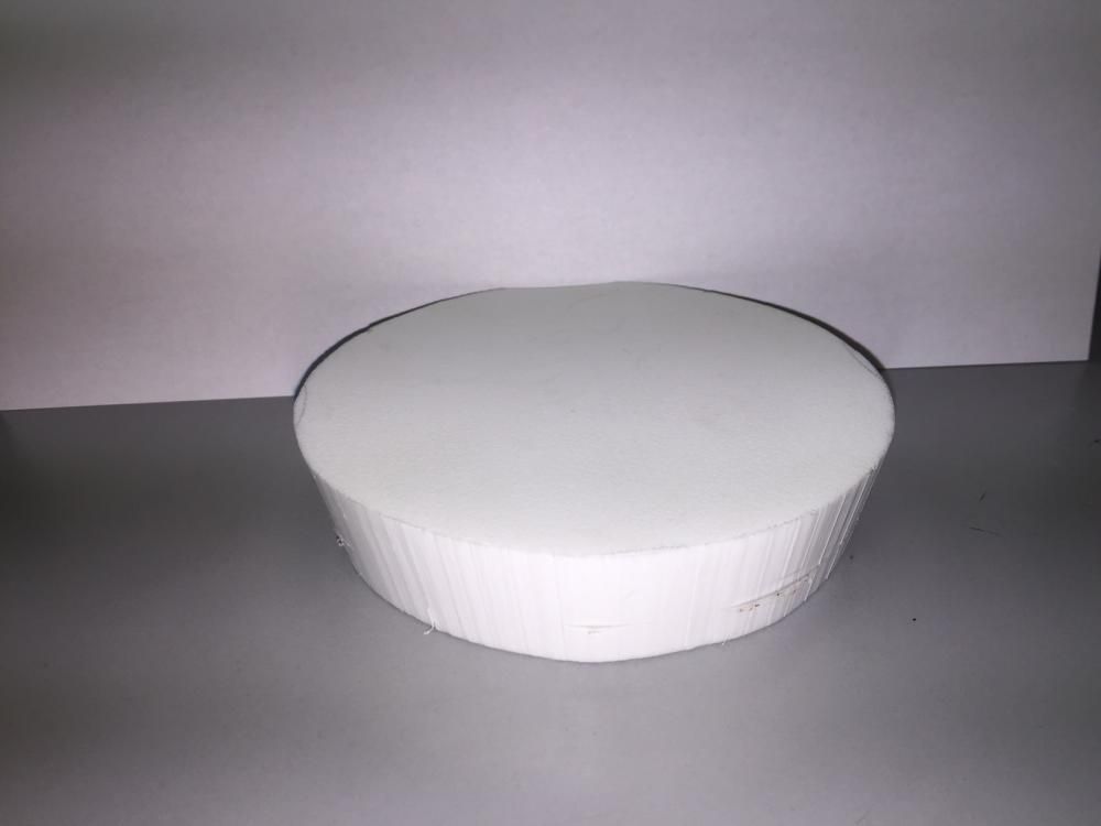 A white round object is sitting on top of a table.