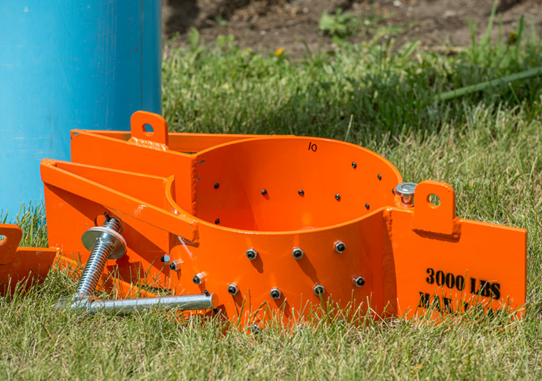 A large orange object is sitting on top of a lush green field.