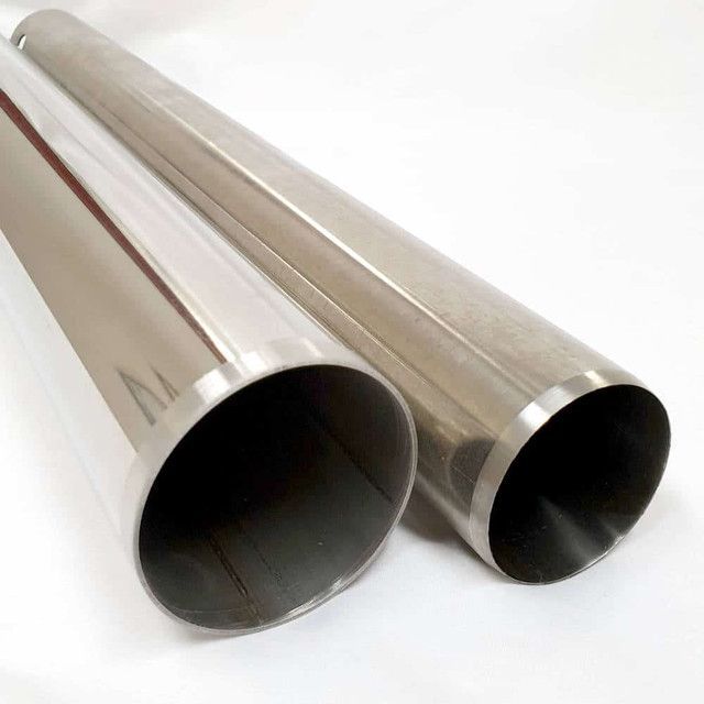 Two stainless steel pipes are sitting next to each other on a white surface.