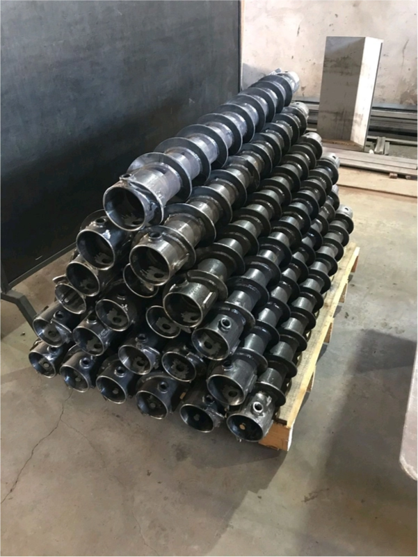A bunch of metal pipes are stacked on top of each other on a wooden pallet.