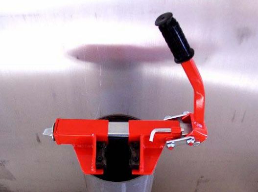 A red object with a black handle is attached to a metal pipe