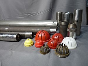 A bunch of different types of pipes and caps are sitting on a table.