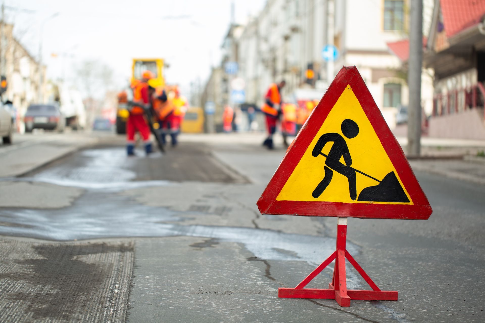 A construction sign is sitting on the side of the road.