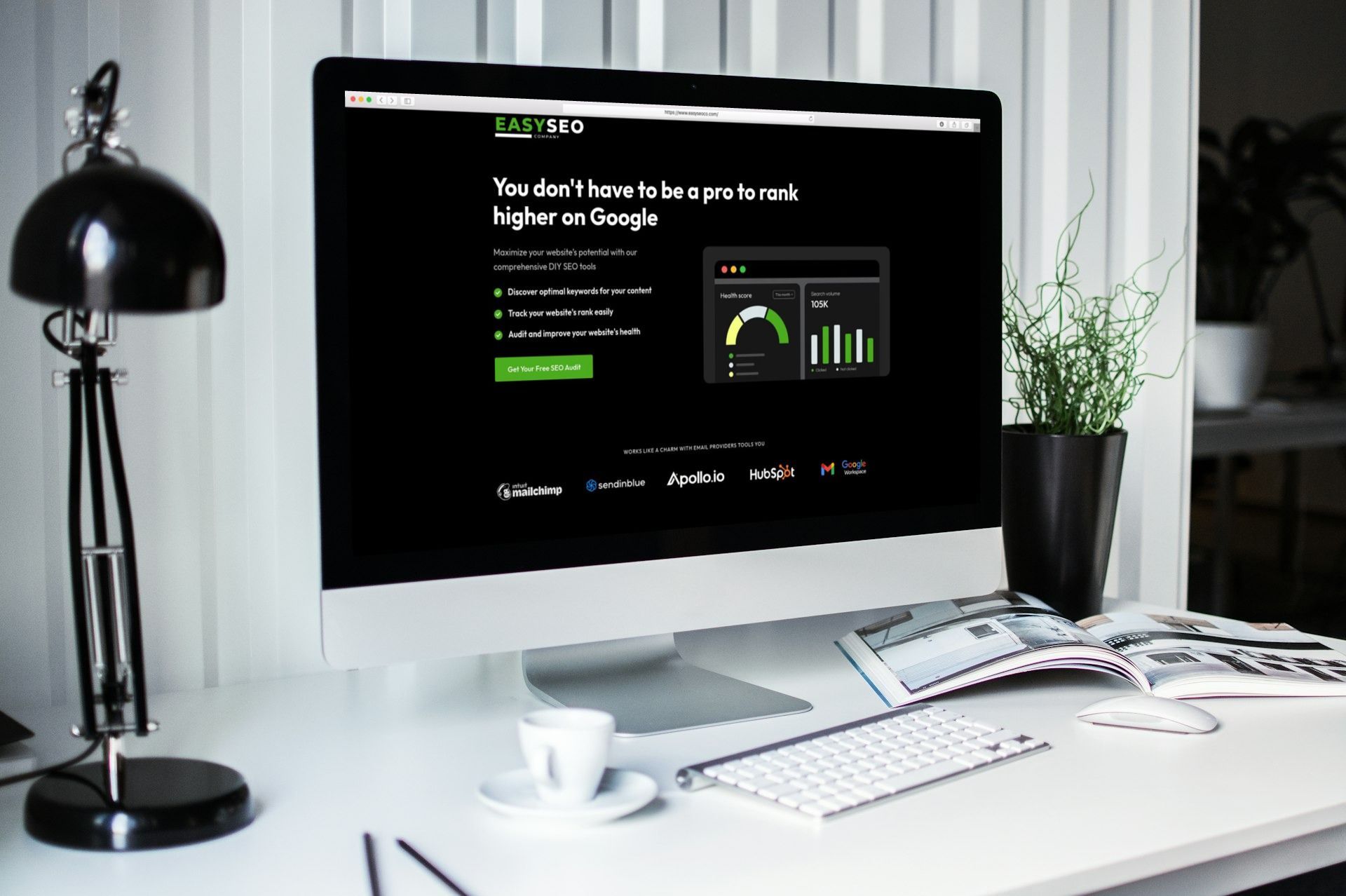 A computer monitor is sitting on a desk next to a lamp.