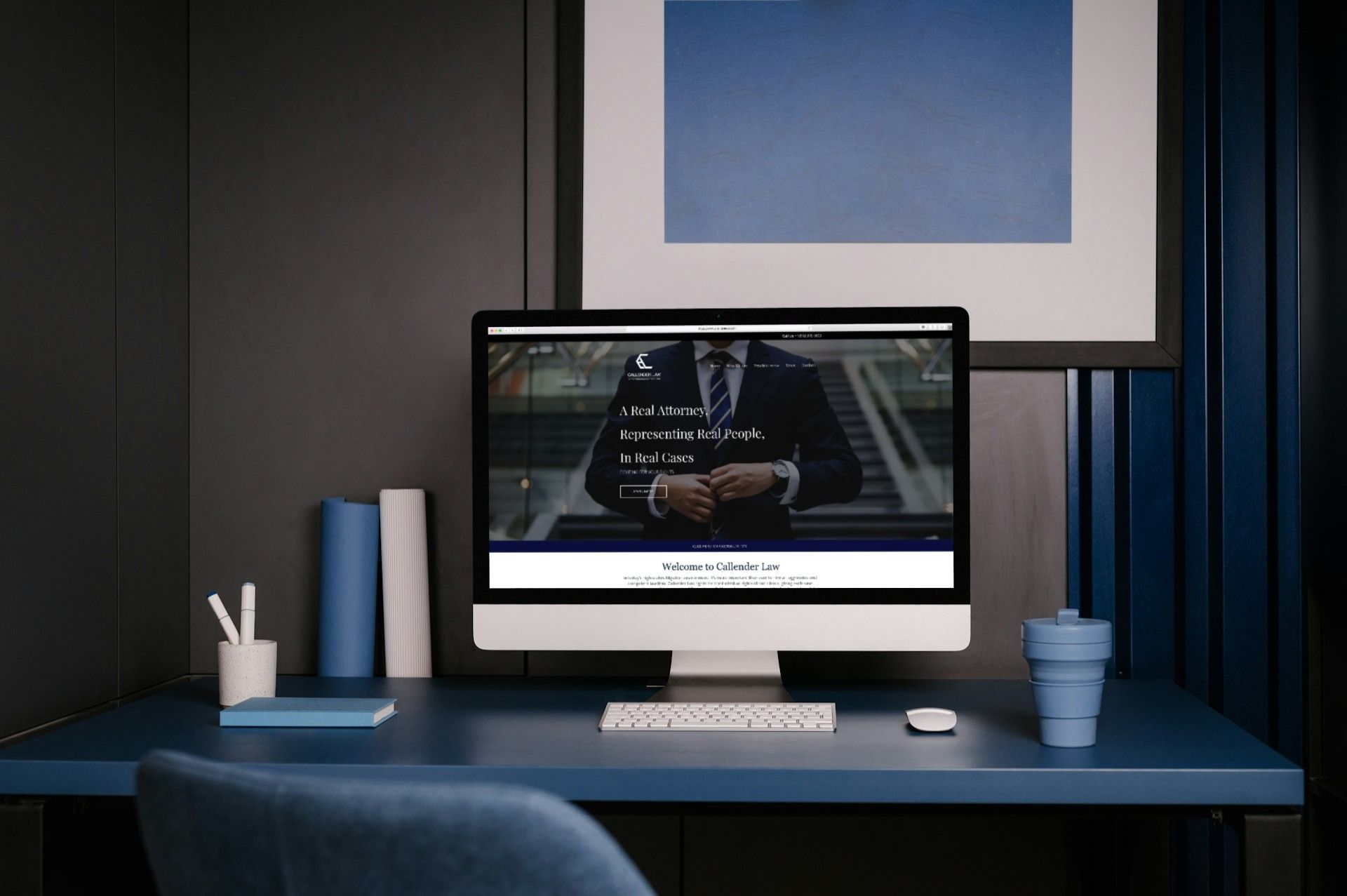 A computer is sitting on a desk with a picture of a man on the screen.