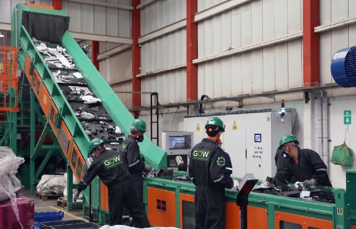 Trabajadores inspeccionando una cinta transportadora verde en un almacén de la fábrica.