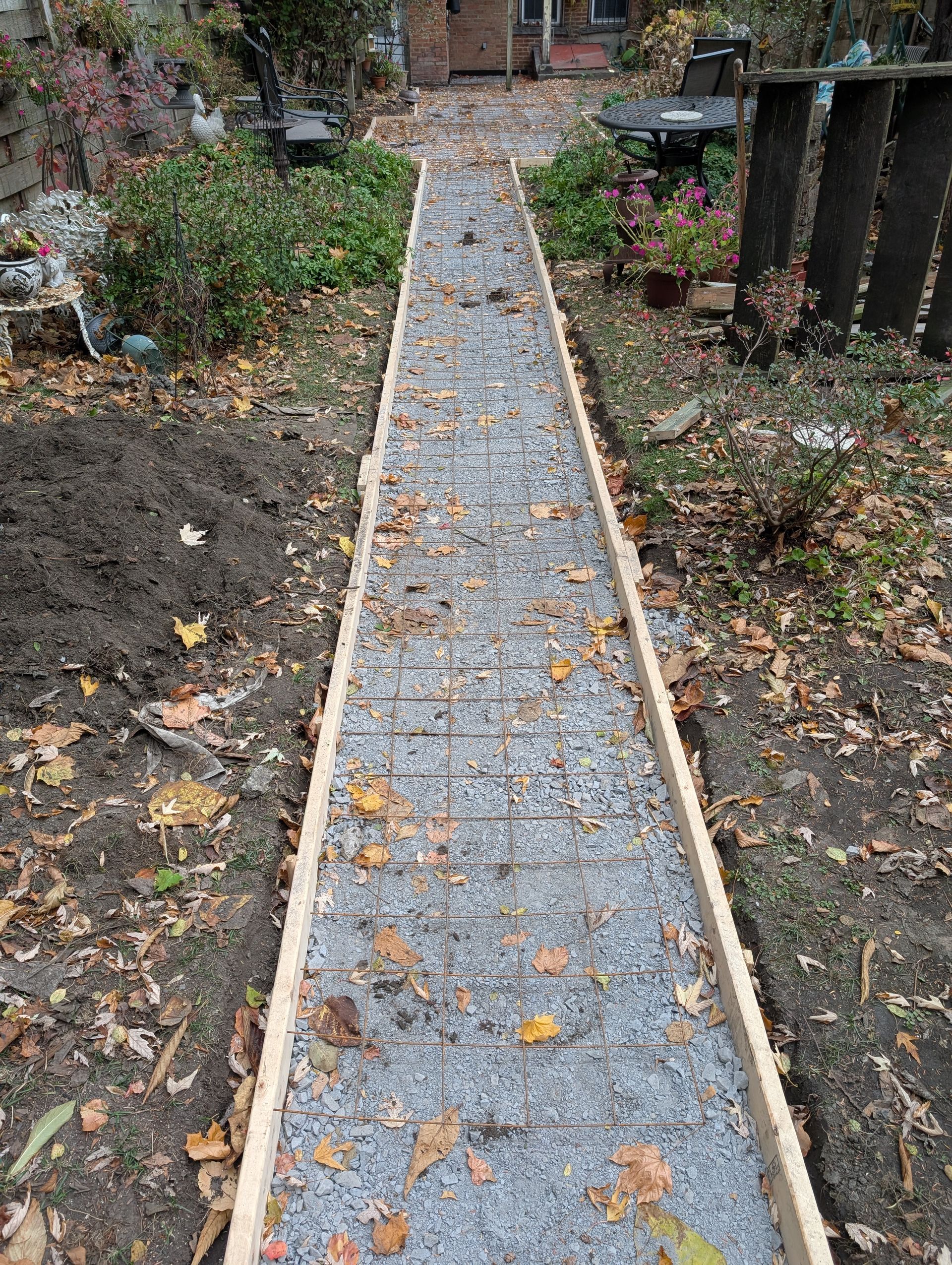 A concrete walkway is being built in a garden.
