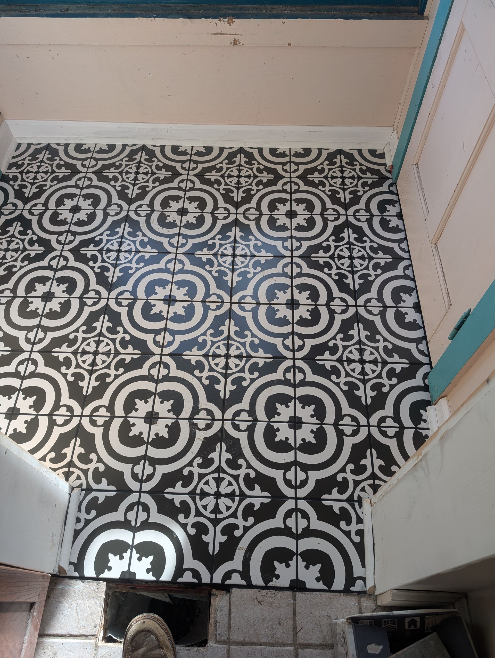 A black and white tile floor with a floral pattern