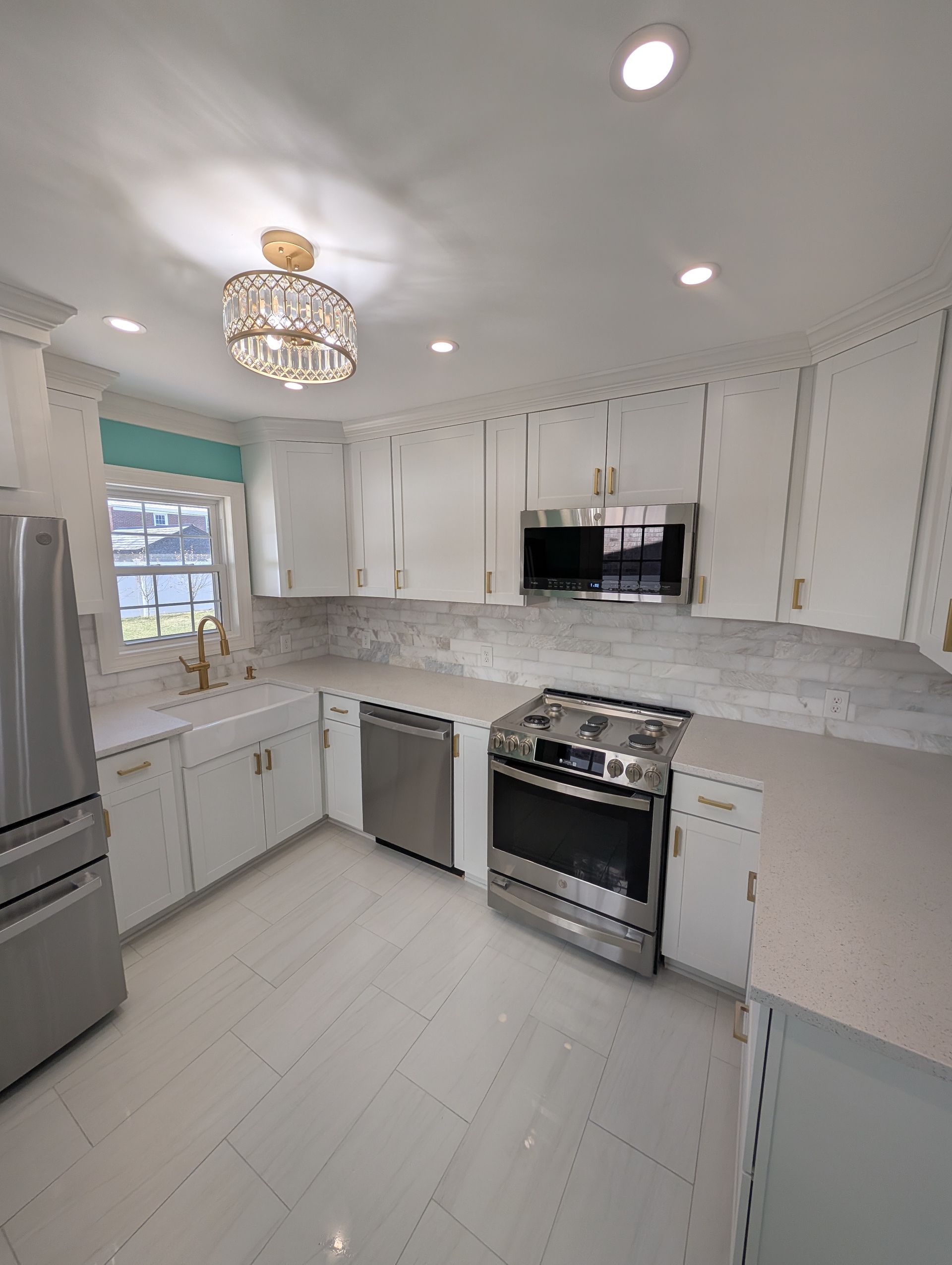 A kitchen with stainless steel appliances and white cabinets.