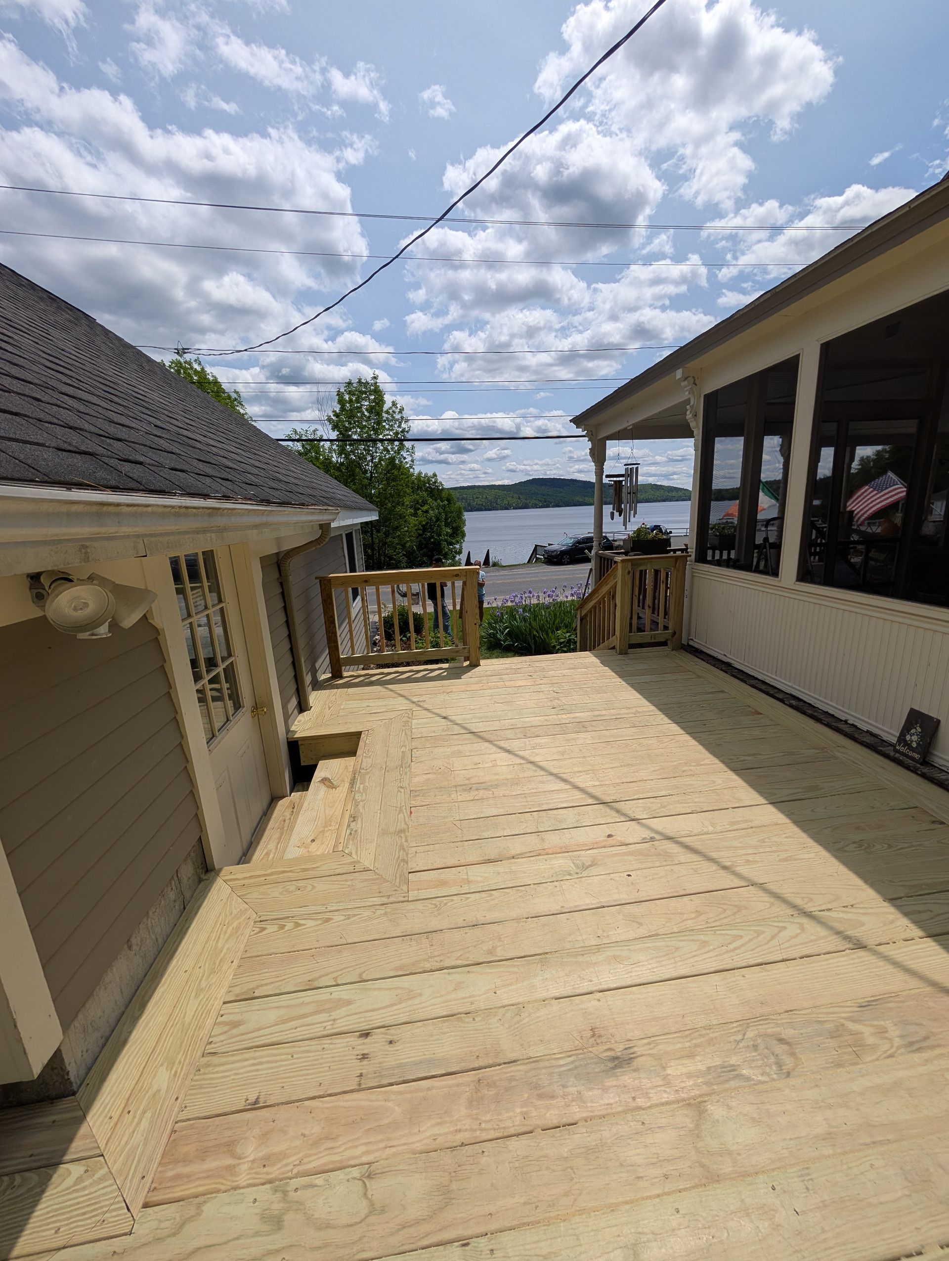 A wooden deck is being built next to a house with a view of the water.