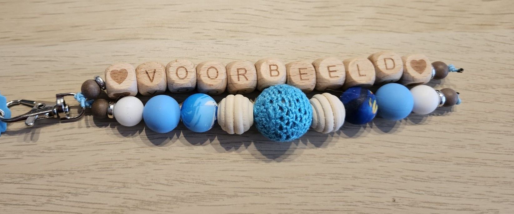 Sleutelhanger van houten kralen met de tekst 