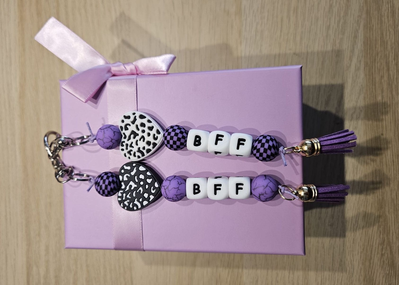 Paarse geschenkdoos met twee kralen sleutelhangers die samen