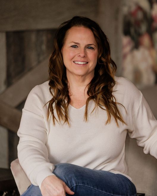 A man and a woman are sitting on a dock overlooking a lake.