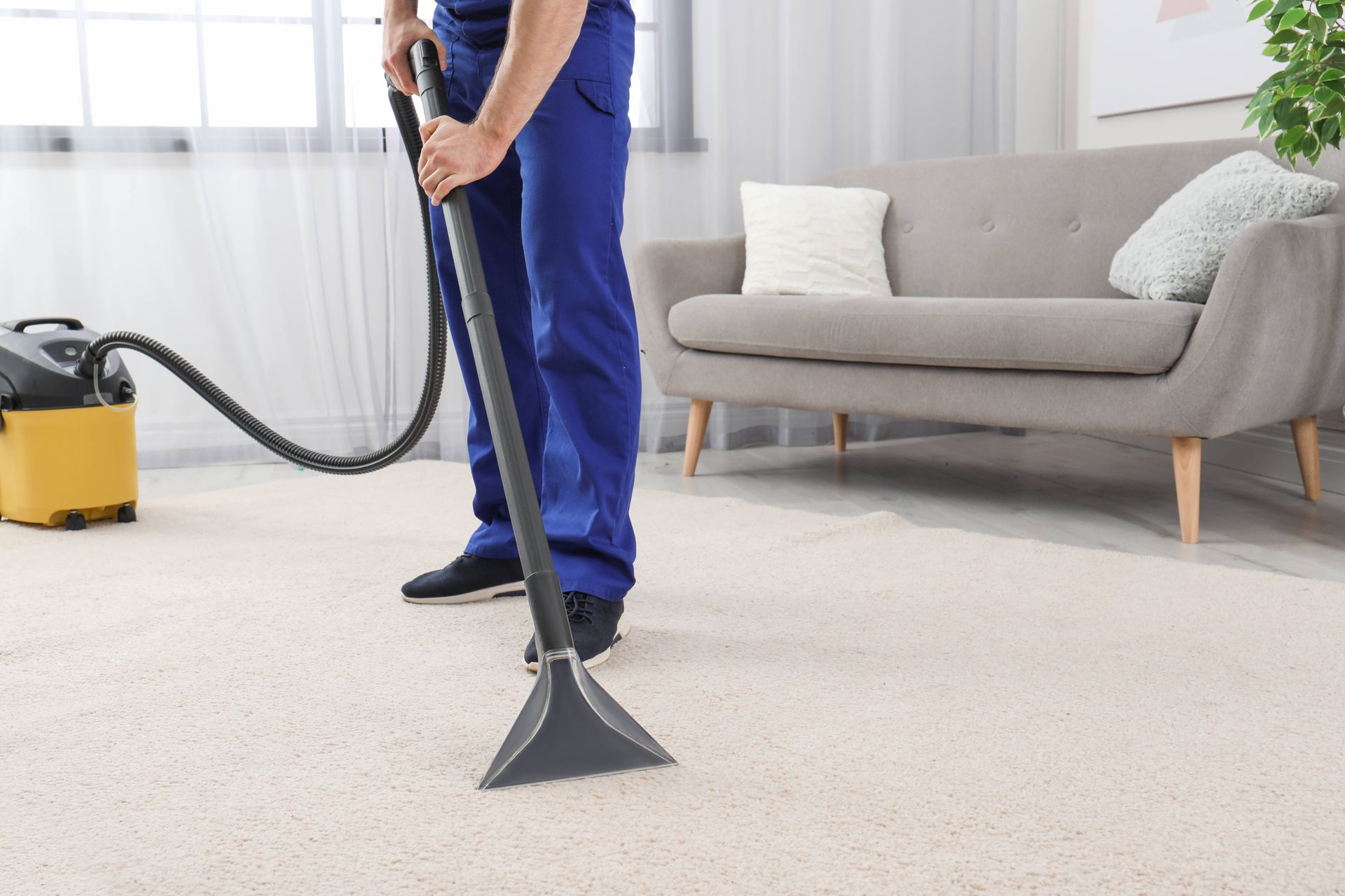 a man is using a vacuum cleaner to clean a carpet in a living room 