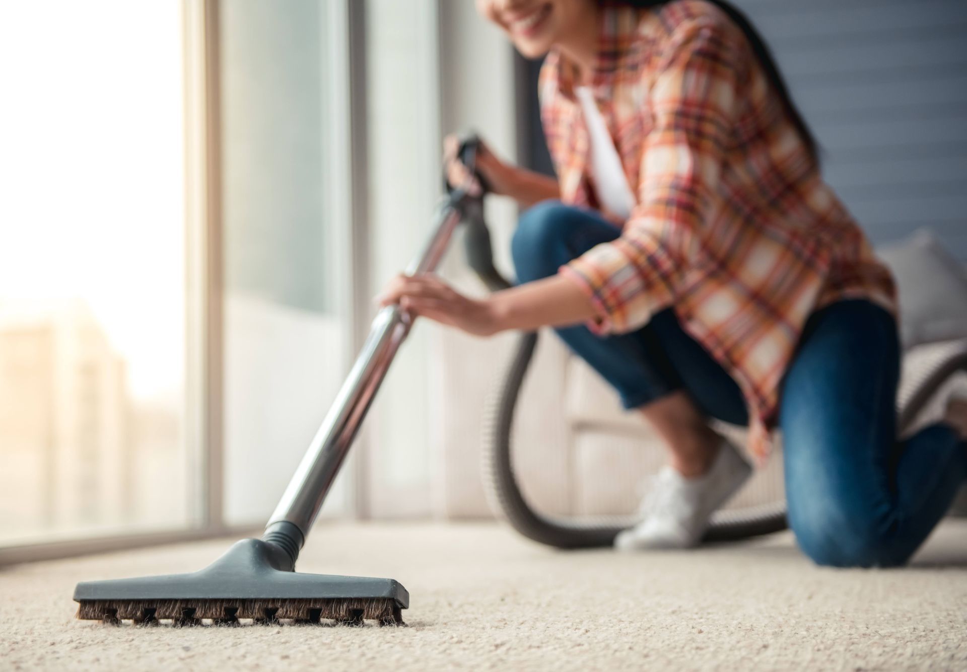 a woman is cleaning the carpet with a vacuum cleaner