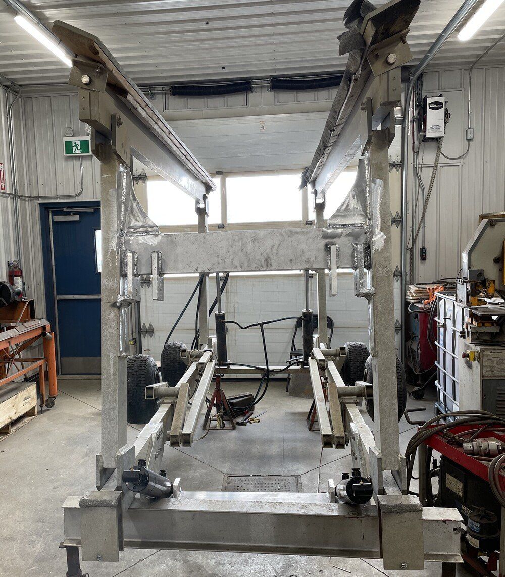 Un grand élévateur de voiture en métal argenté dans un cadre d'atelier.