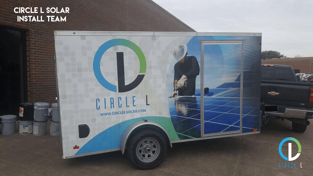 A circle l solar install team trailer is parked in front of a building.