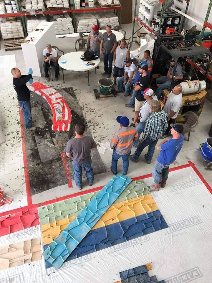 A group of men are standing around a table in a warehouse.