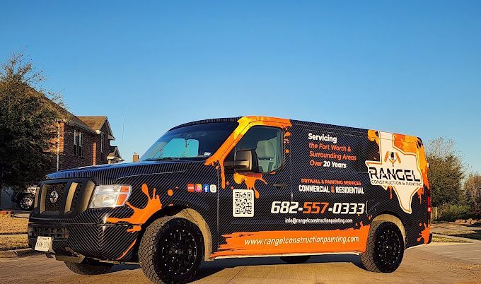 A black and orange van is parked on the side of the road.