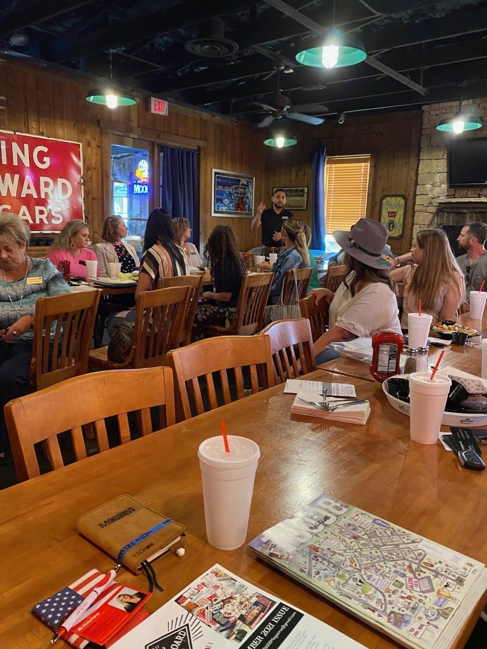 A group of people are sitting at tables in a restaurant.