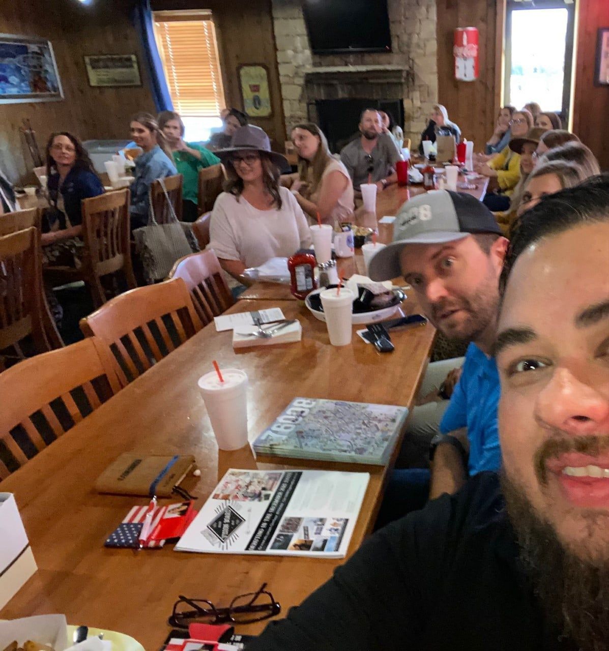 A group of people are sitting at long tables in a restaurant