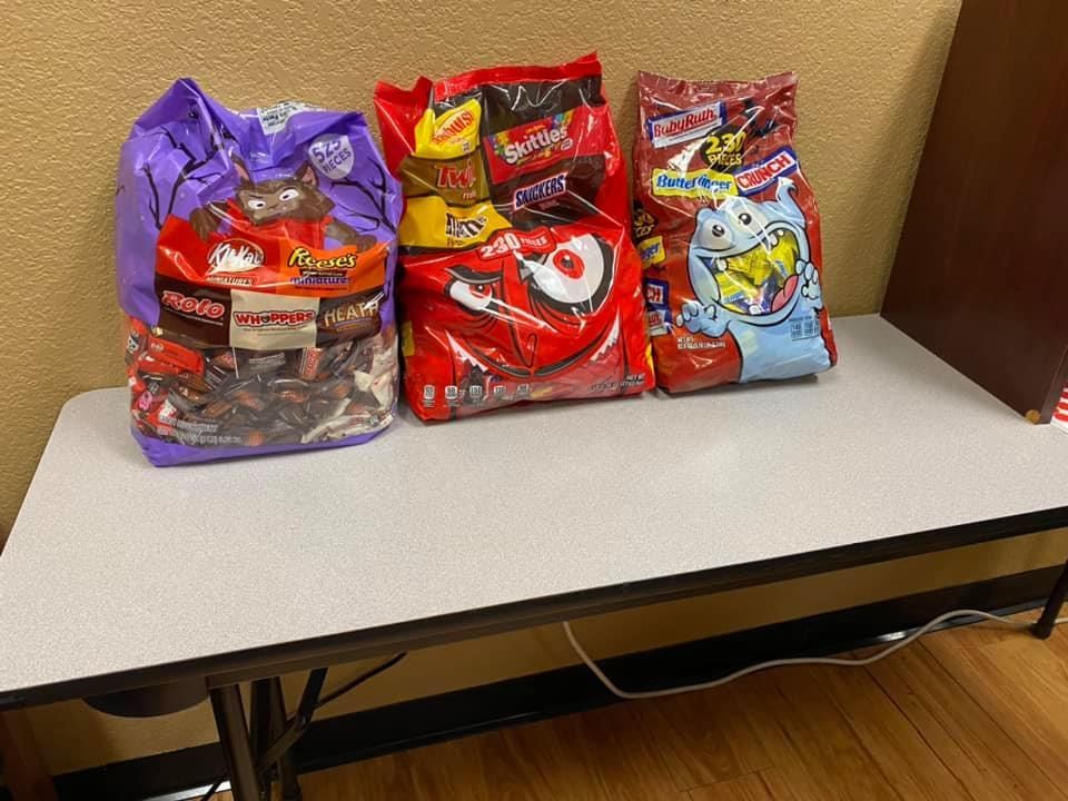 Three bags of candy are sitting on a table.