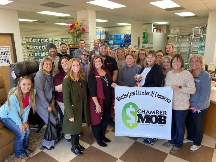 A group of people are standing in a room holding a banner that says chamber mob.